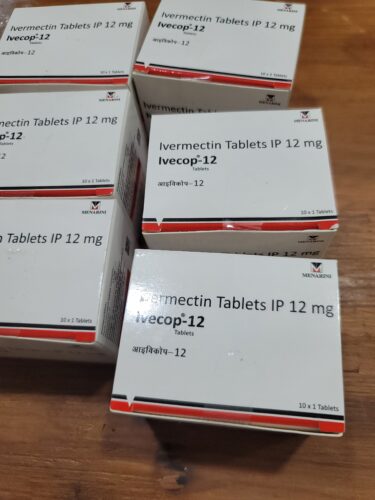 Boxes of Ivecop-12 (ivermectin tablets IP 12 mg) by Menarini on a wooden surface.